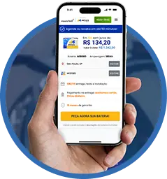 Mão segurando um celular com o site Moura Fácil aberto